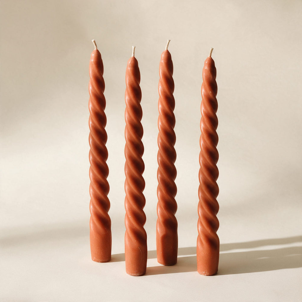 Quatre bougies torsadées Montsouris en cire végétale terracotta, sur fond crème