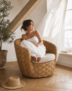 Fauteuil Saint-Germain en rotin naturel tressé avec coussin lin — mise en scène dans un appartement sous les toits — Maison Mansarde
