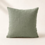 Coussin Buttes-Chaumont en lin lavé coloris vert sauge, de face sur fond crème