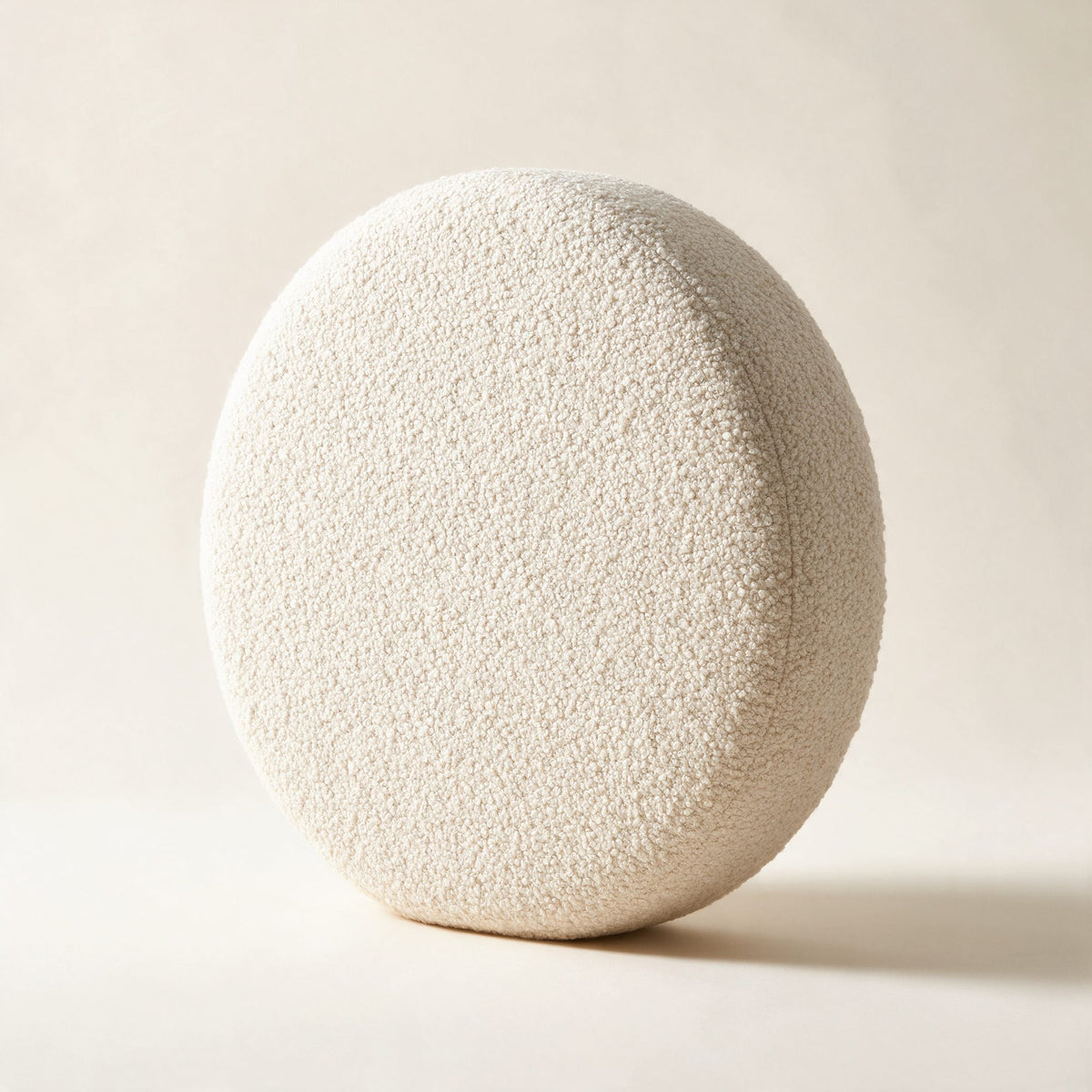 Coussin rond Monceau en bouclette écrue, sur fond crème