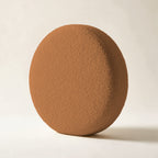 Coussin rond Monceau en bouclette caramel, sur fond crème