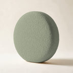 Coussin rond Monceau en bouclette vert sauge, sur fond crème