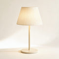 Lampe sans fil Solférino crème à abat-jour plissé, allumée, sur fond crème