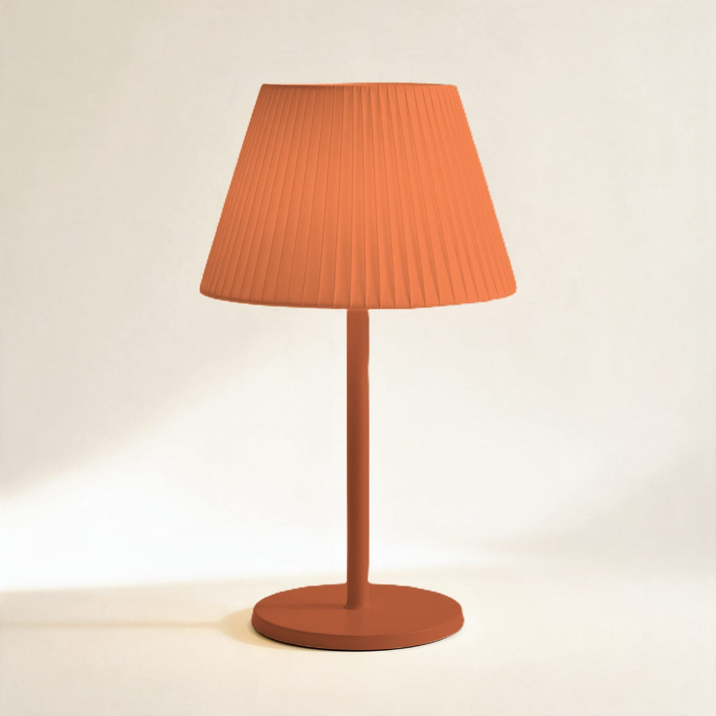 Lampe sans fil Solférino terracotta à abat-jour plissé, allumée, sur fond crème