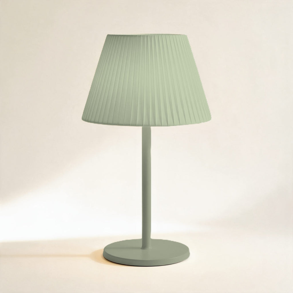 Lampe sans fil Solférino vert sauge à abat-jour plissé, allumée, sur fond crème