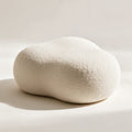 Pouf Nuage en bouclette écrue au contour organique, sur fond crème
