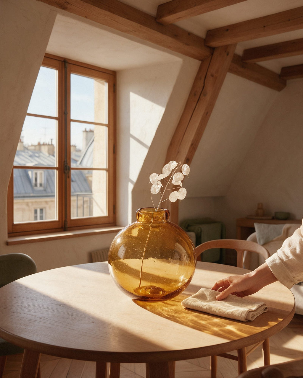 Vase bulle Tuileries en verre ambré sur une table en chêne, traversé par la lumière dorée d’un appartement parisien